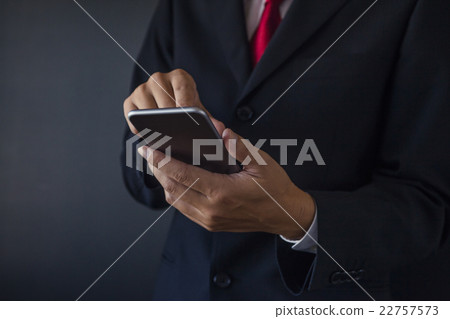 一個商人用智能手機手 22757573