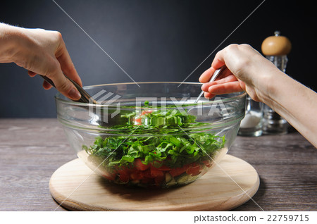 Girl stirs cooked vegetarian vegetable salad Girl stirs cooked vegetarian vegetable salad 22759715