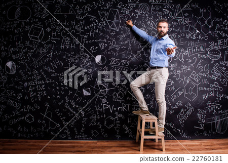 Man writing on big blackboard with mathematical 22760181