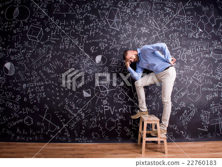 Man at step ladder, against big blackboard Man at step ladder, against big blackboard 22760183