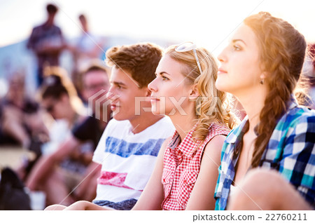 Teenagers at summer music festival, sitting on the Teenagers at summer music festival, sitting on the 22760211