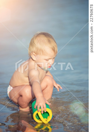Cute baby playing on the sandy beach and in sea 22760678
