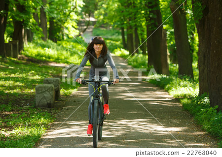 cyclist woman riding a bicycle in park 22768040