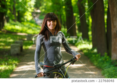 cyclist woman riding a bicycle in park 22768048