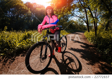 圖庫照片: cyclist woman riding a bicycle in park