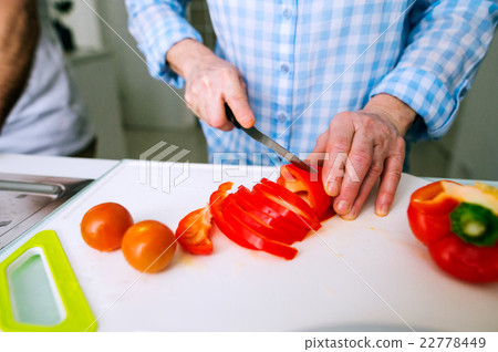 Hands of unrecognizable senior woman cutting red Hands of unrecognizable senior woman cutting red 22778449
