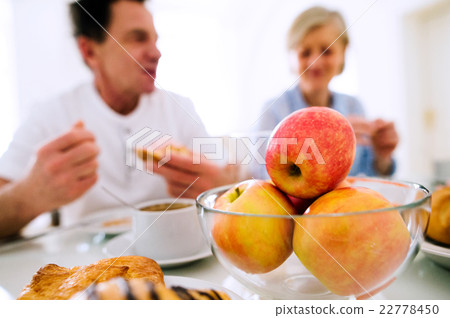 Morning meal. Senior man and woman having Morning meal. Senior man and woman having 22778450