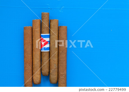 Detail of luxury Cuban cigars on the blue table Detail of luxury Cuban cigars on the blue table 22779499
