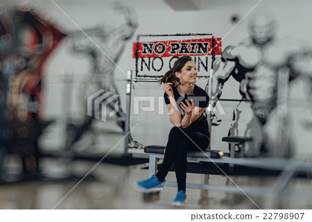 Beautiful girl at the gym listening to music Beautiful girl at the gym listening to music 22798907