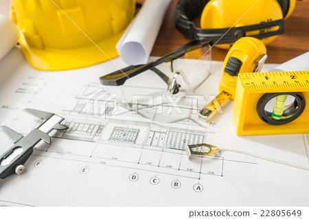Construction plans with yellow helmet and drawing tools on blueprints . Construction plans with yellow helmet and drawing tools on blueprints . 22805649