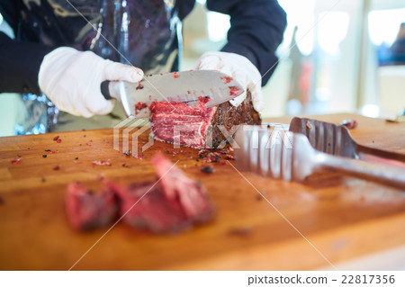 Butcher cutting slices of fresh beef 22817356