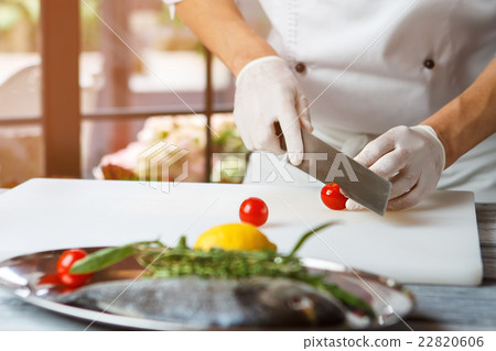 Hands with knife cut tomato. 22820606