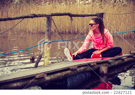 Girl training in sporty clothes on lake shore Girl training in sporty clothes on lake shore 22827121