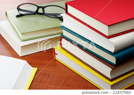 被堆積的書和玻璃在書桌上 22837060