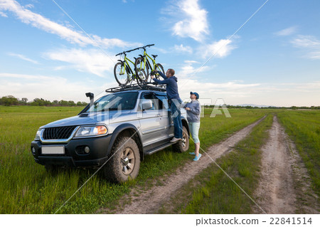 Young couple taking off their bicycles from rack 22841514