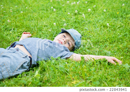 Little caucasian boy resting on grass 22843941