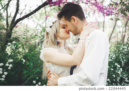 Young beautiful couple kissing and hugging near Young beautiful couple kissing and hugging near 22844445