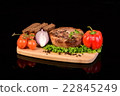 Round meat steak on a wooden board with vegetables 22845249