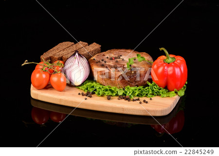 Round meat steak on a wooden board with vegetables 22845249