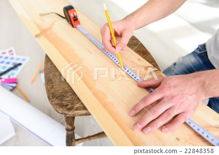 Man measuring piece of wood Man measuring piece of wood 22848358