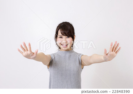 A young smile with a smile putting both hands forward in front of a white background 22848390