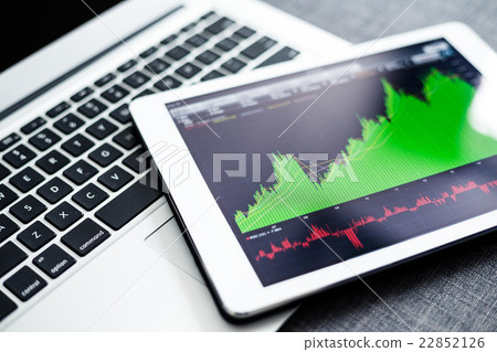 Stock market graphs on tablet pc with laptop computer 22852126