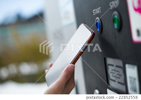 Customer paying though NFC on parking machine Customer paying though NFC on parking machine 22852558
