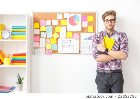 Young guy standing with notebook 22852788