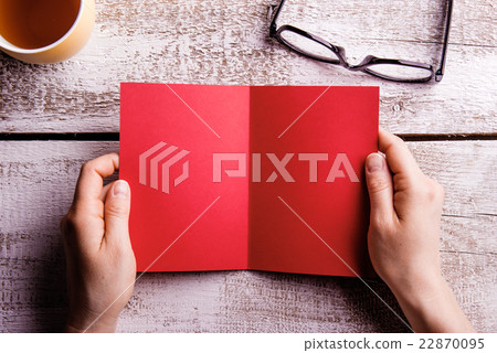 Unrecognizable woman holding empty red greeting Unrecognizable woman holding empty red greeting 22870095
