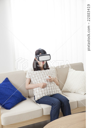 A woman immersed in virtual reality with VR equipment A woman immersed in virtual reality with VR equipment 22883419