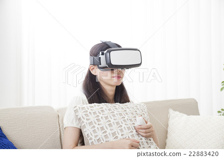 A woman immersed in virtual reality with VR equipment A woman immersed in virtual reality with VR equipment 22883420