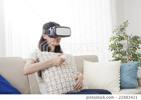 A woman immersed in virtual reality with VR equipment A woman immersed in virtual reality with VR equipment 22883421