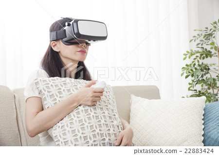 A woman immersed in virtual reality with VR equipment A woman immersed in virtual reality with VR equipment 22883424
