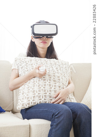 A woman immersed in virtual reality with VR equipment A woman immersed in virtual reality with VR equipment 22883426