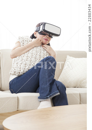 A woman immersed in virtual reality with VR equipment A woman immersed in virtual reality with VR equipment 22883434