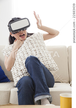 A woman immersed in virtual reality with VR equipment A woman immersed in virtual reality with VR equipment 22883439
