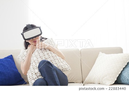 A woman immersed in virtual reality with VR equipment A woman immersed in virtual reality with VR equipment 22883440