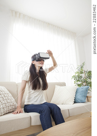 A woman immersed in virtual reality with VR equipment 22883462
