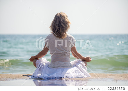 Woman meditating at the sea Woman meditating at the sea 22884850