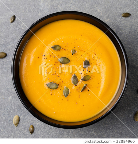 Pumpkin cream soup with pumpkin seeds, black bowl Pumpkin cream soup with pumpkin seeds, black bowl 22884960
