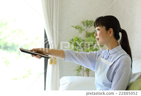 Housewife operating TV remote control 22885052