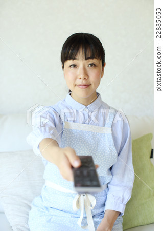 Housewife operating TV remote control 22885053