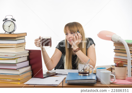Girl student doing night sadly looks at another cup of coffee Girl student doing night sadly looks at another cup of coffee 22886351
