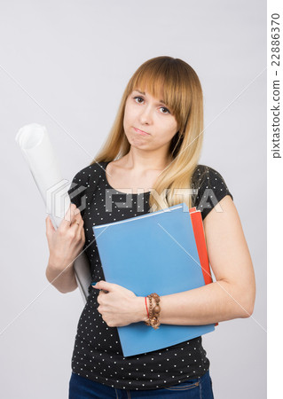 Young girl student with a project in hand and angrily looks into the frame 22886370