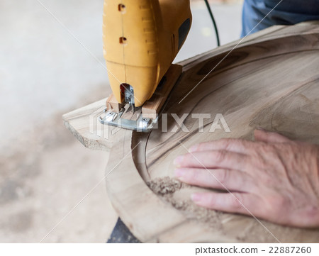 Carpenter is cutting a board with fretsaw Carpenter is cutting a board with fretsaw 22887260
