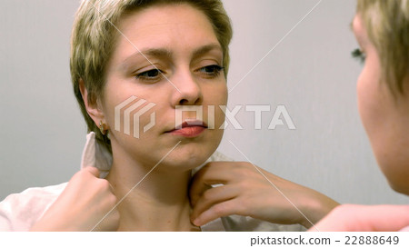 Blond business woman dresses and smarten at mirror 22888649