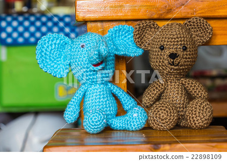 Elephant and bear dolls on a wood desk Elephant and bear dolls on a wood desk 22898109