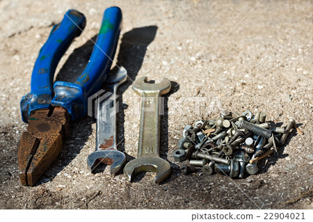 Pliers, wrenches, screws on the concrete floor Pliers, wrenches, screws on the concrete floor 22904021