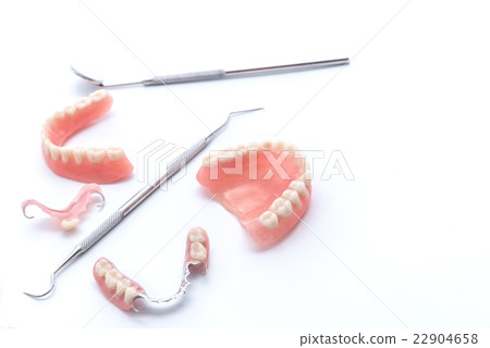 Set of dentures and dental tools on white Set of dentures and dental tools on white 22904658