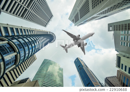 Tall city buildings and a plane flying overhead  22910688